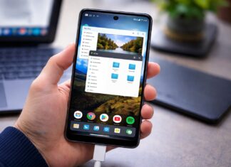 A close-up shot of a person holding a Google Pixel phone in their hand, displaying Android 17's desktop mode.